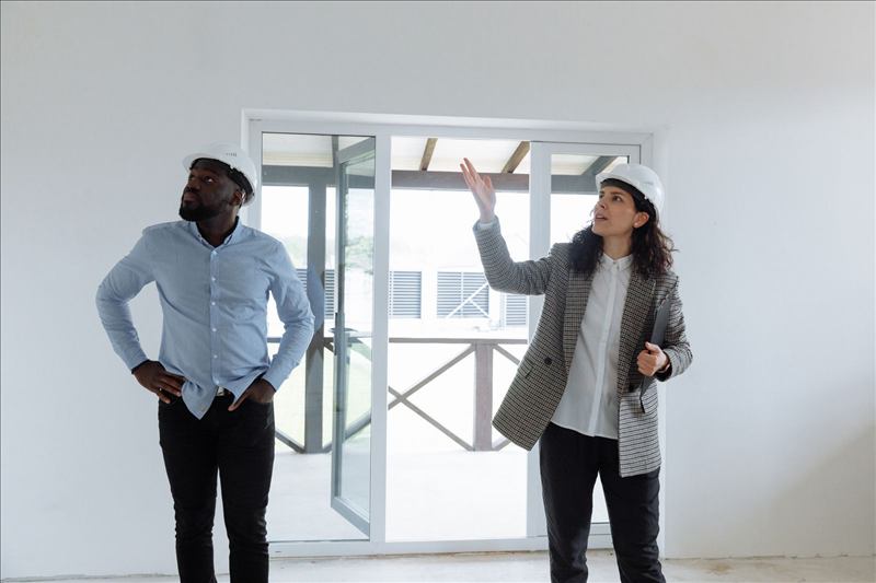 Dos personas con casco revisando una obra en interior