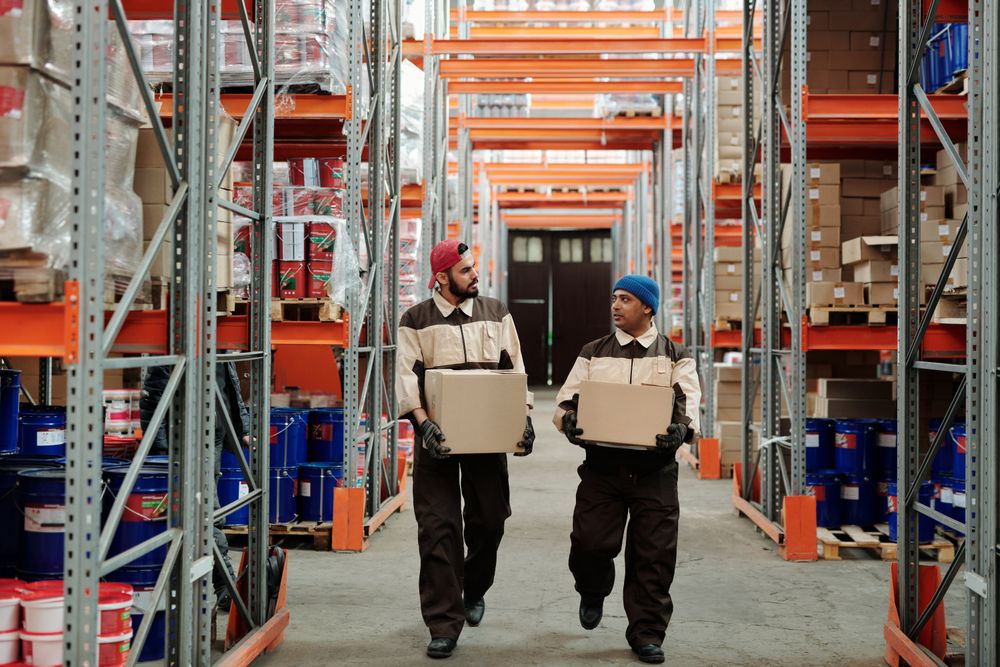 Operarios moviendo cajas en una bodega de distribución