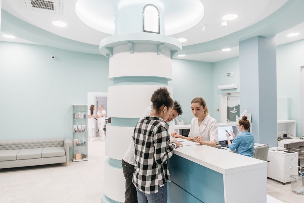 Recepción de una clínica atendiendo a pacientes
